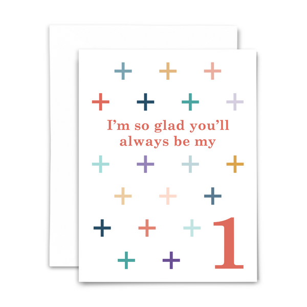 "I'm so glad you'll always be my +1" greeting card; coral serif font surrounded by grid of + in various colors (blues, teals, golds, corals, pinks, purples) on white background; blank interior with white envelope
