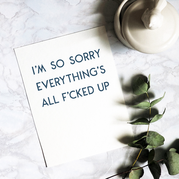 Greeting card: 'I'm so sorry everything's all f*cked up' with blank interior; blue font on white card