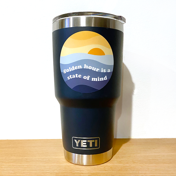 Golden Hour is a State of Mind vinyl sticker; on navy blue Yeti mug