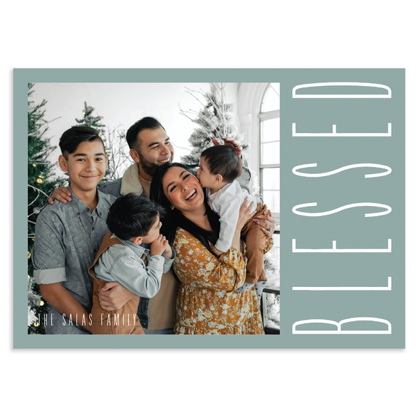 Custom holiday photo card with square image and 'BLESSED' text overlay on a light blue background with horizontal orientation