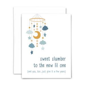 Folded A2 greeting card with blank interior and white envelope; front reads "sweet slumber to the new lil one (and you, too...just give it a few years)" with moon, star and cloud mobile above in shades of blue and gold on white background