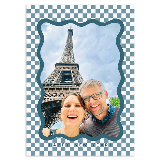 Custom holiday photo card with single vertical image surround by blue scalloped border on a white and blue checkered background