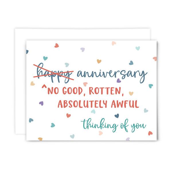 Folded A2 greeting card with blank interior and white envelope; front reads, ""no good, rotten, absolutely awful anniversary ~ thinking of you" in blue, coral and teal fonts with scattered multi-colored hearts on white background
