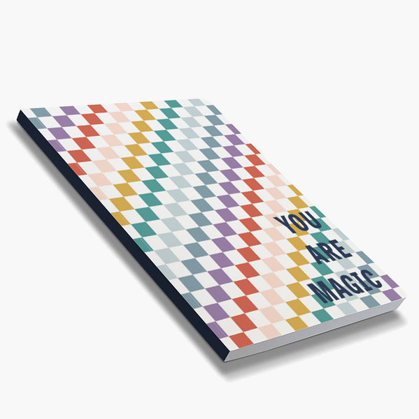 ront cover of dot grid 72-page notebook with soft touch cover; rainbow checkered pattern alternating with white with "You are magic" text in navy block letters