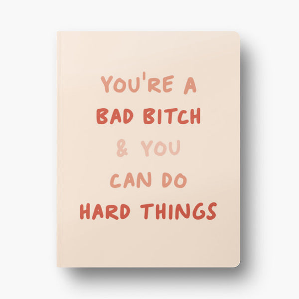 Front cover of dot grid 72-page notebook with soft touch cover "You're a bad bitch & you can do hard things" in shades of pink with blush background