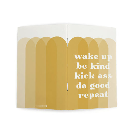 Front and back cover of dot grid pocket notebook with large white text WAKE UP BE KIND KICK ASS DO GOOD REPEAT atop 4 overlapping vertical arches in various shades of gold