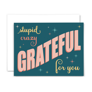 Retro-style thank you greeting card "stupid crazy grateful for you" in yellow and pink fonts on dark teal background with colorful stars and light teal dots; with white envelope