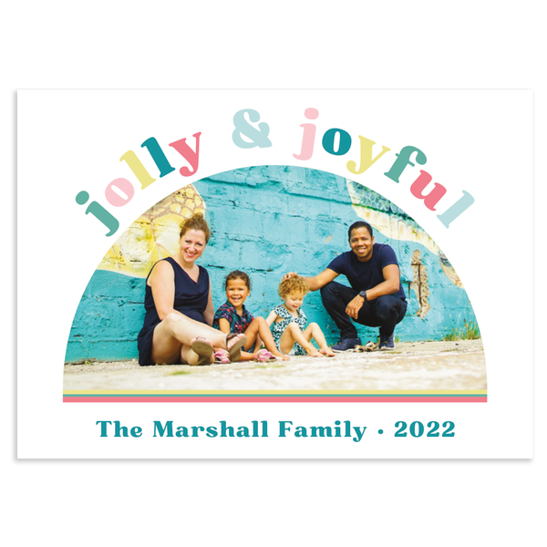 Custom holiday photo card; 1 photo in half moon with "jolly & joyful" text in colorful block letters in arch above photo; on white background