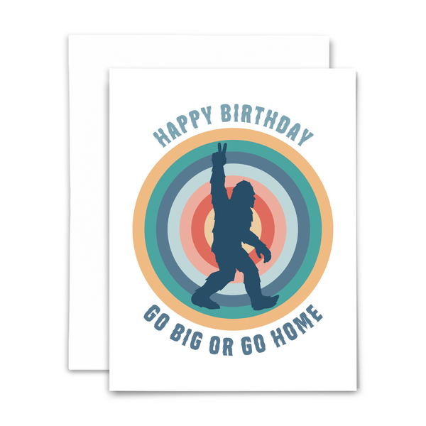 blank greeting card "happy birthday go big or go home" in hairy blue font with navy bigfoot silhouette over colorful concentric circles on white background with white envelope